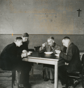 876779 Afbeelding van vier mannen die aan het eten zijn in het klooster Genazzano van de Zusters Augustinessen van ...